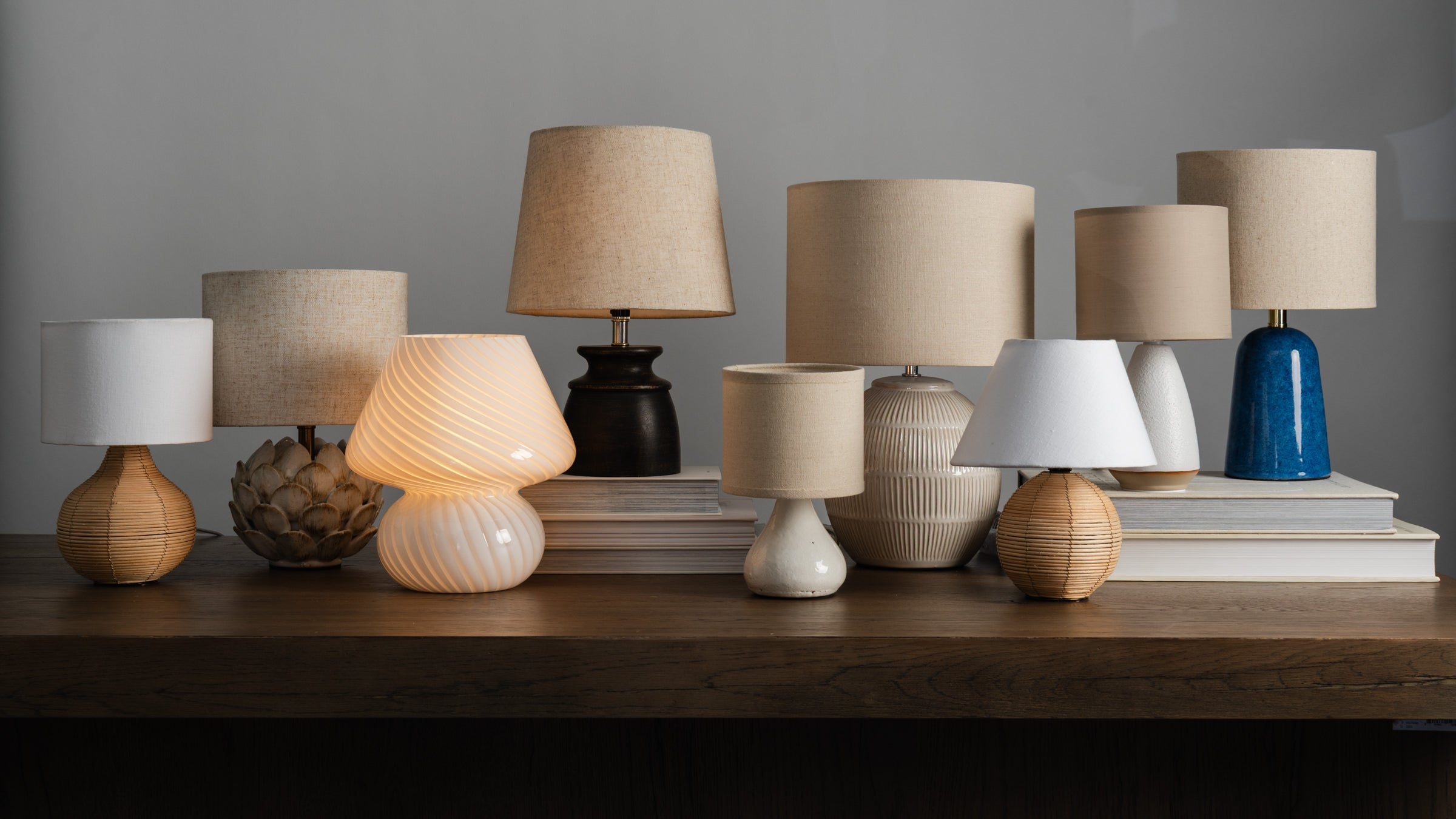 Collection of table lamps on a wood table at Addison West