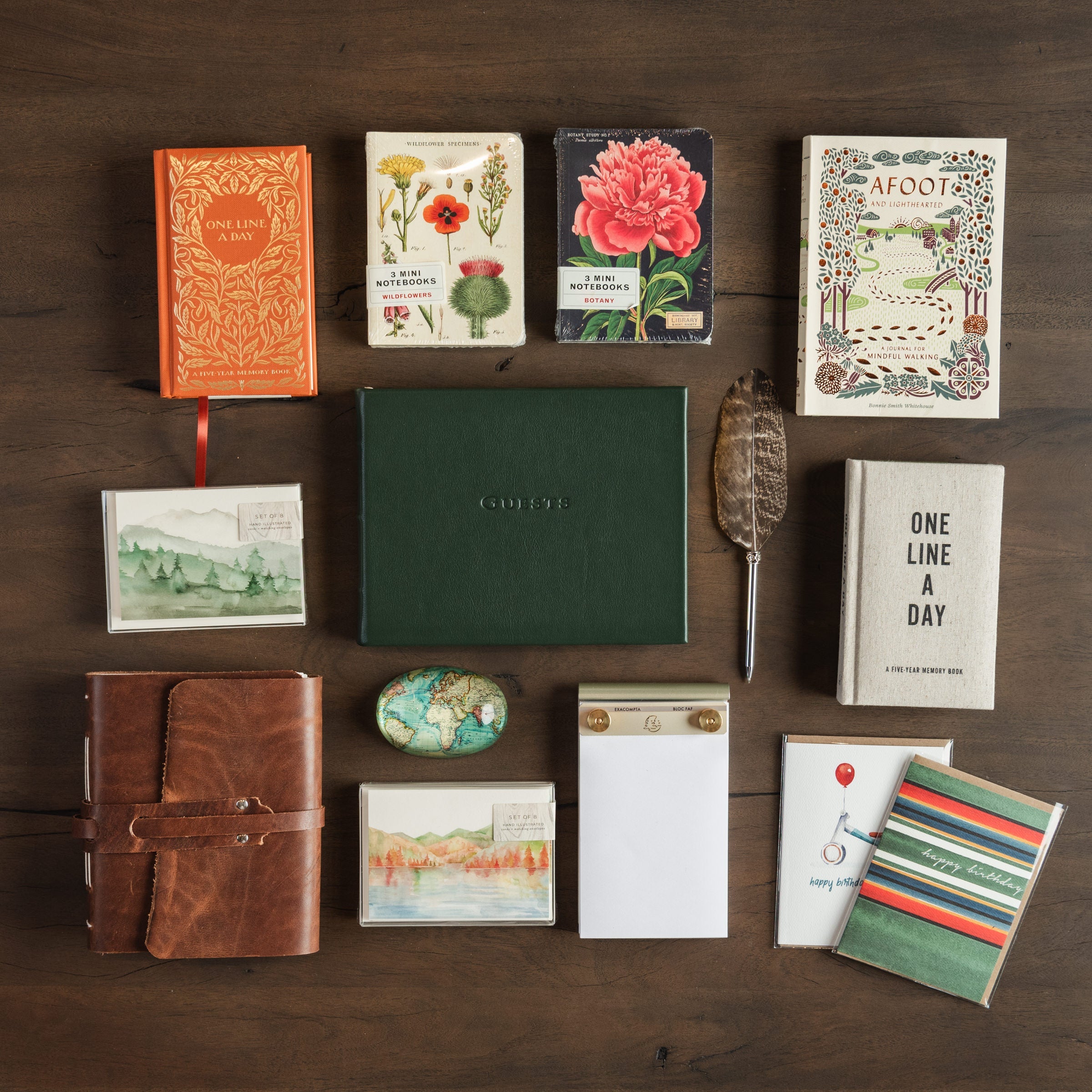 Collection of journals, stationary, notecards, greeting cards on a dark wood table at Addison West