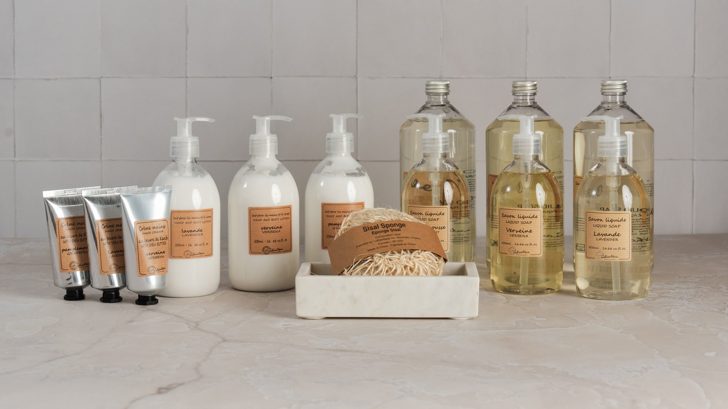 Collection of natural non-toxic hand soaps and moisturizers from Lothantique on a marble table at Addison West