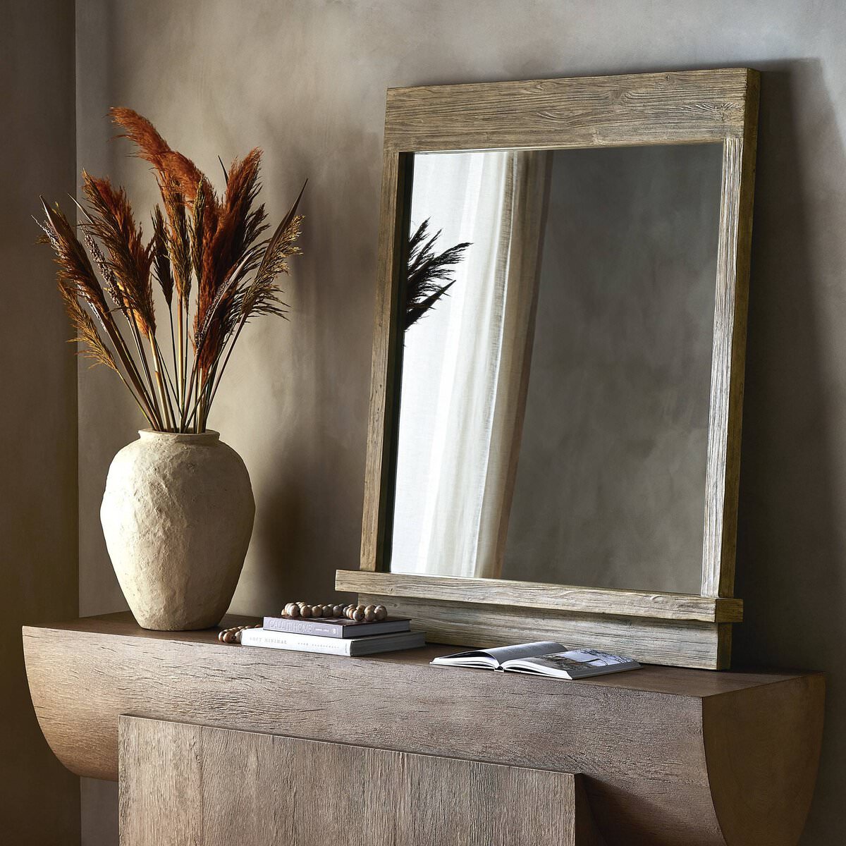 Rustic wood framed square mirror on a console table in an entryway at Addison West