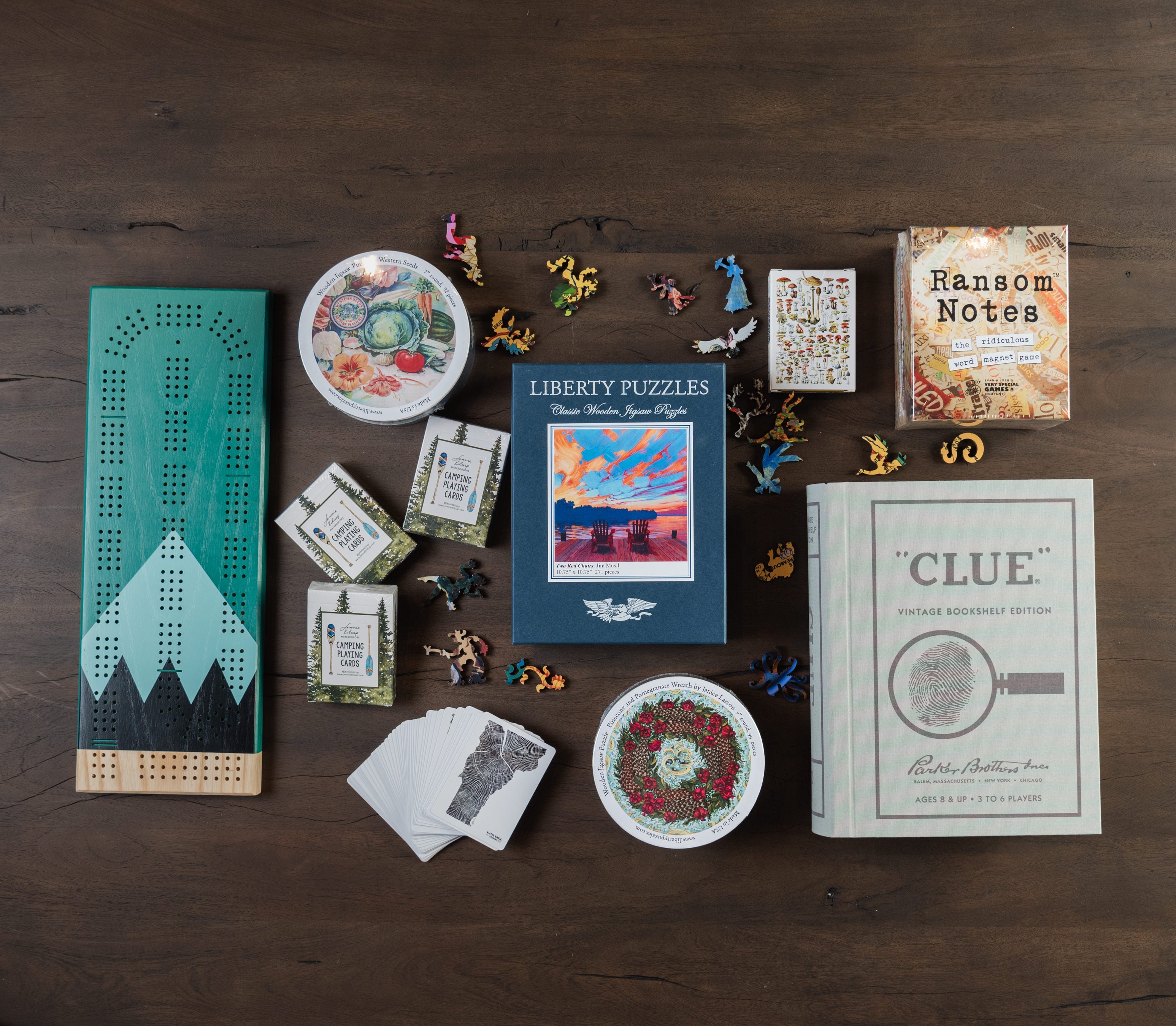 View from above of liberty puzzles, clue book game, cribbage set, ransom notes, and playing cards on a table at Addison West