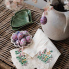 Wicker trunk with gingko plates and embroidered napkins and easter eggs