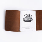 Handmade leather hiking journal with strap on white background