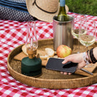 LED rechargeable Light and Sound LED Lantern on a picnic tray and blanket with a hand and iphone