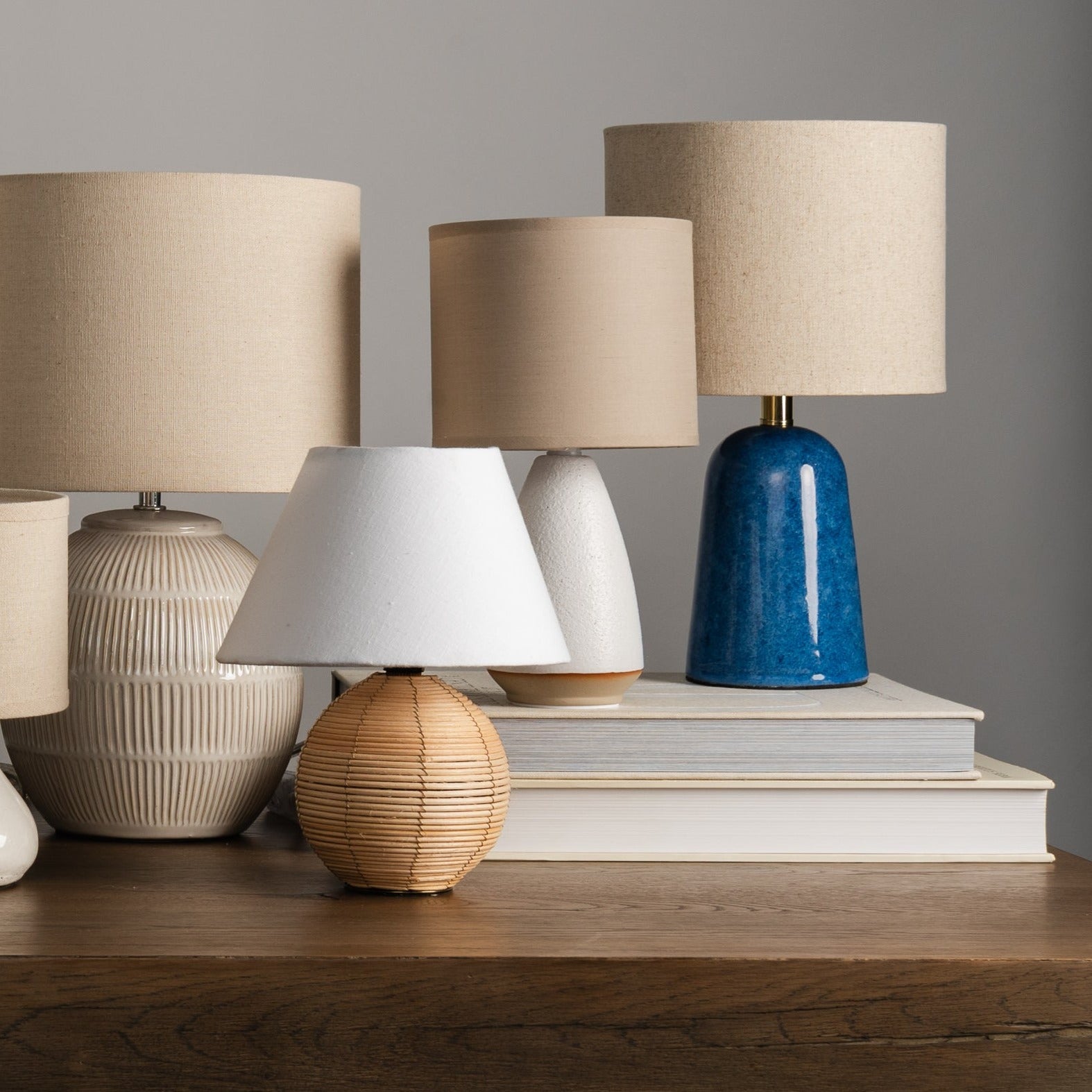 Group of small lamps stacked on top of books on a table