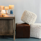 Collection of mini lamps on a desk next to a collection of poufs on a white background and blue floor