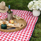 Red and White Check Outdoor Picnic Blanket with navy blue backside on a lawn