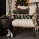 Vermont Hand Hooked Throw Pillow on a cozy chair in front of a holiday tree