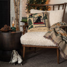 Lab on Ski Lift Hand Hooked Throw Pillow on a cozy chair in front of a holiday tree