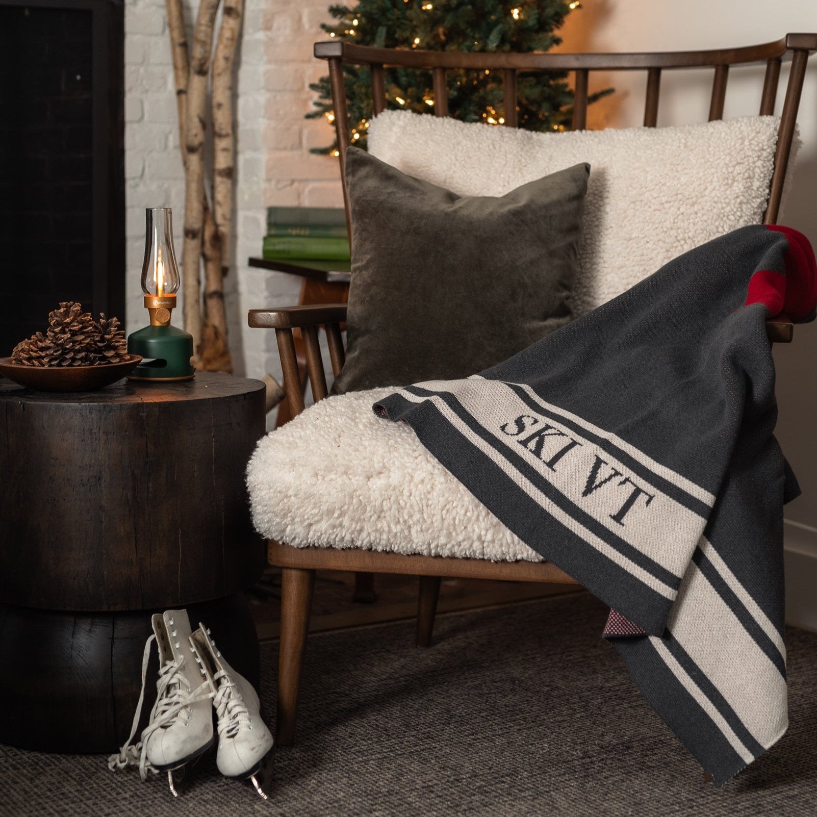 Ski VT Swiss Cross Throw Blanket on a cozy chair in front of a holiday tree