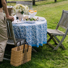 reclangular basket bag with leather handles and black accent weave at an outdoor dining table