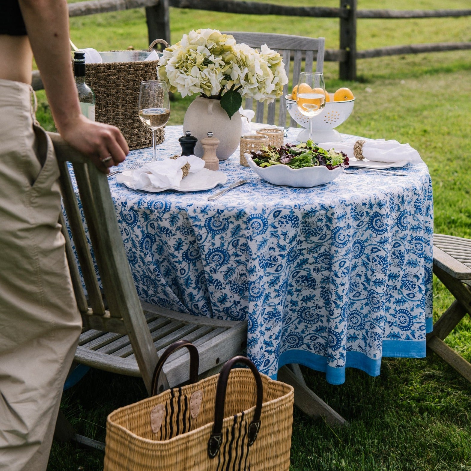 Blue floral tablecloth on a table outside set for outdoor dining