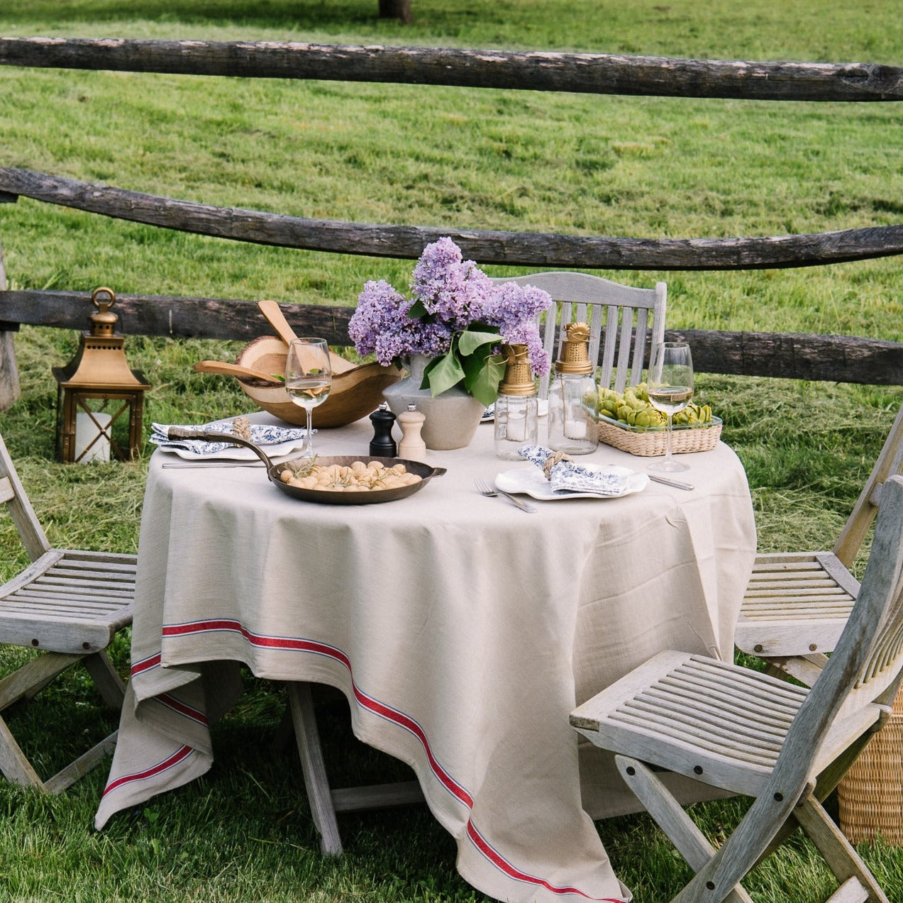 Reactive glaze white stoneware vase with handles on both sides on an outdoor table