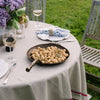 Smithey farmhouse carbon steep skillet on an outdoor dining table on a green lawn