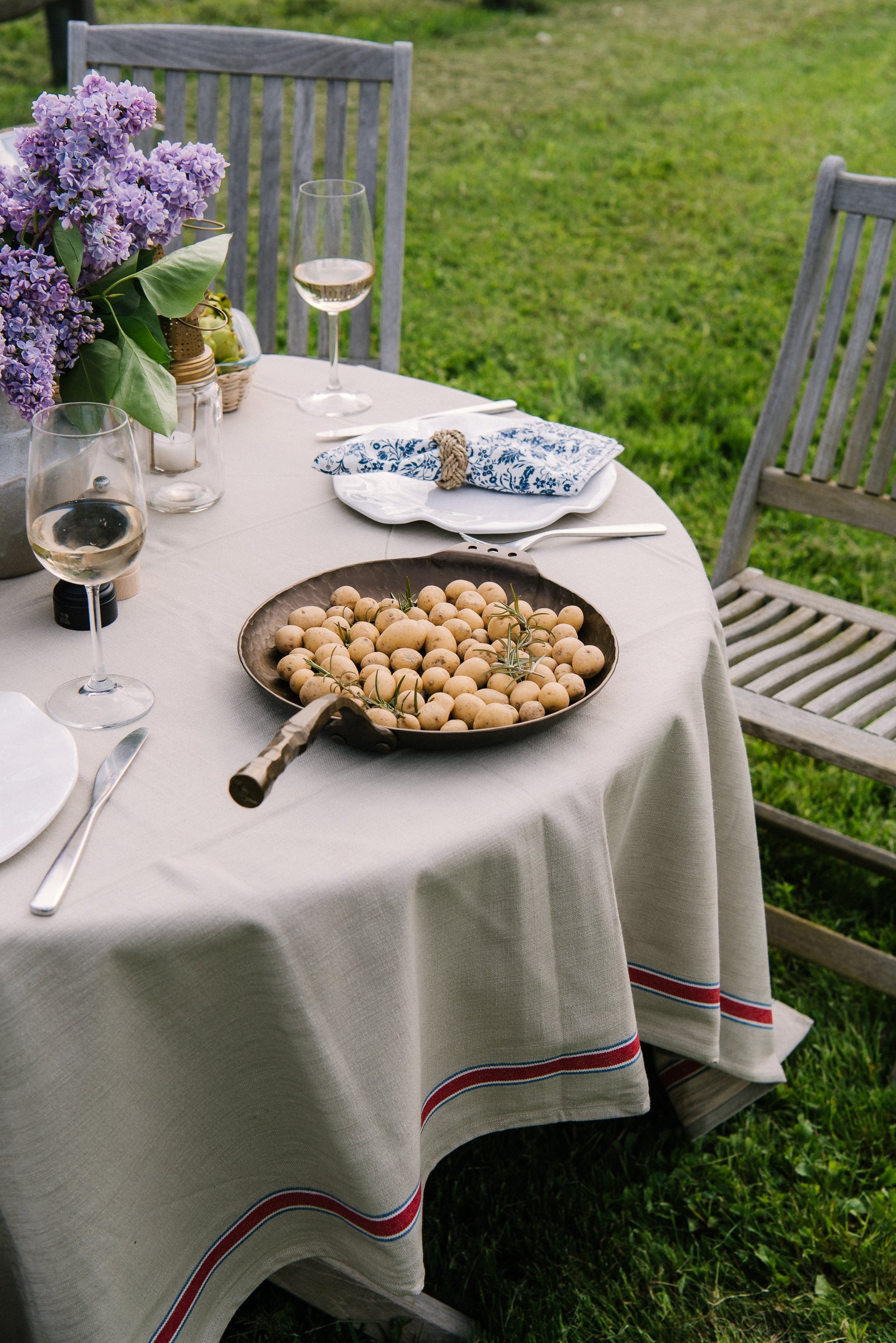 French Laundry Red Tablecloth 60" X 120" beige with red stripe on an outdoor dining table