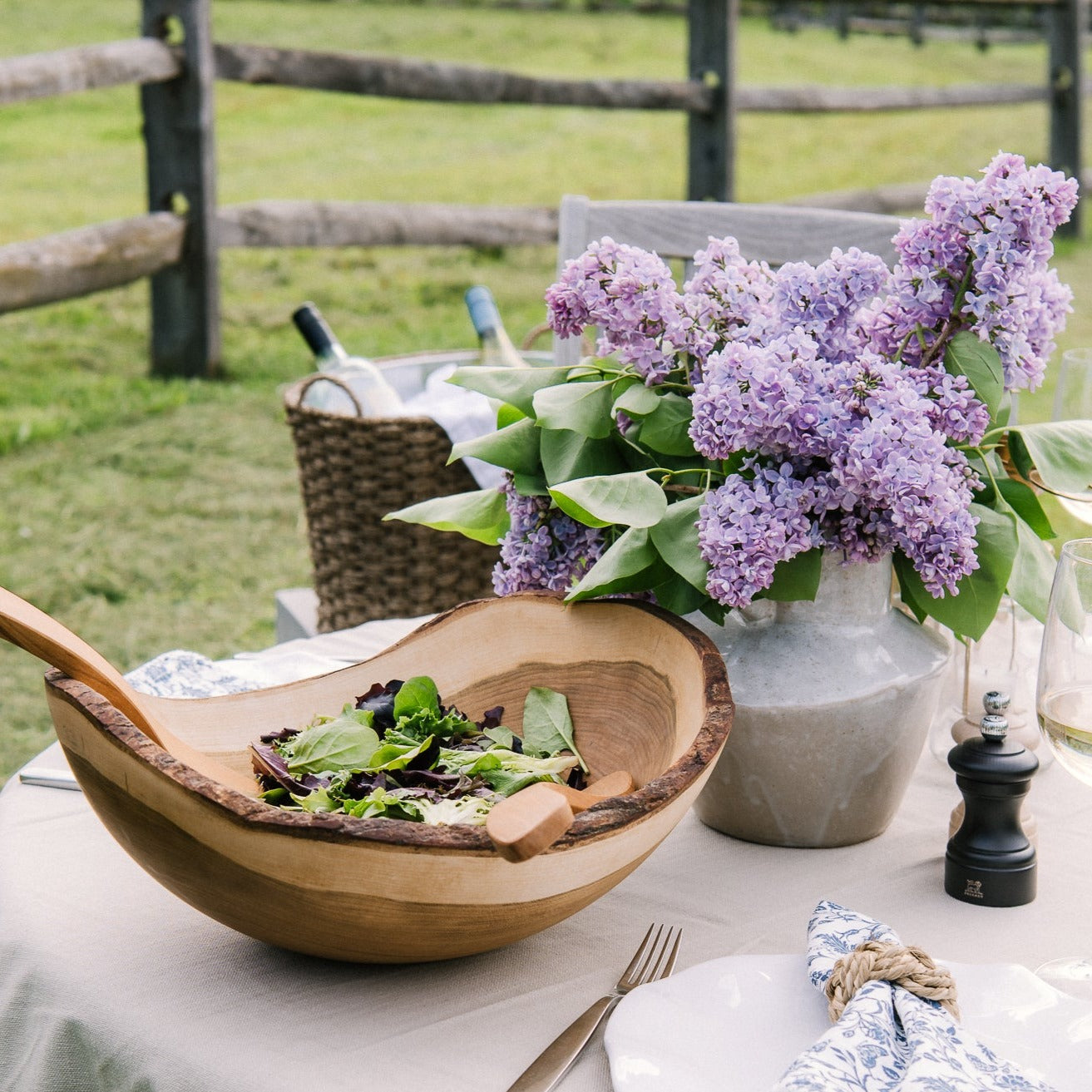 Reactive glaze white stoneware vase with handles on both sides on an outdoor dining table