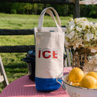 Retro ice logo canvas whine tote on a white background on a red and white checked table outside