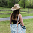 Model wearing Brixton Houston Cowboy Hat in Natural with a black tank top in a field