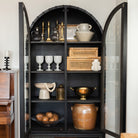 Mercana steel and glass arch top cabinet in a room with a wood floor