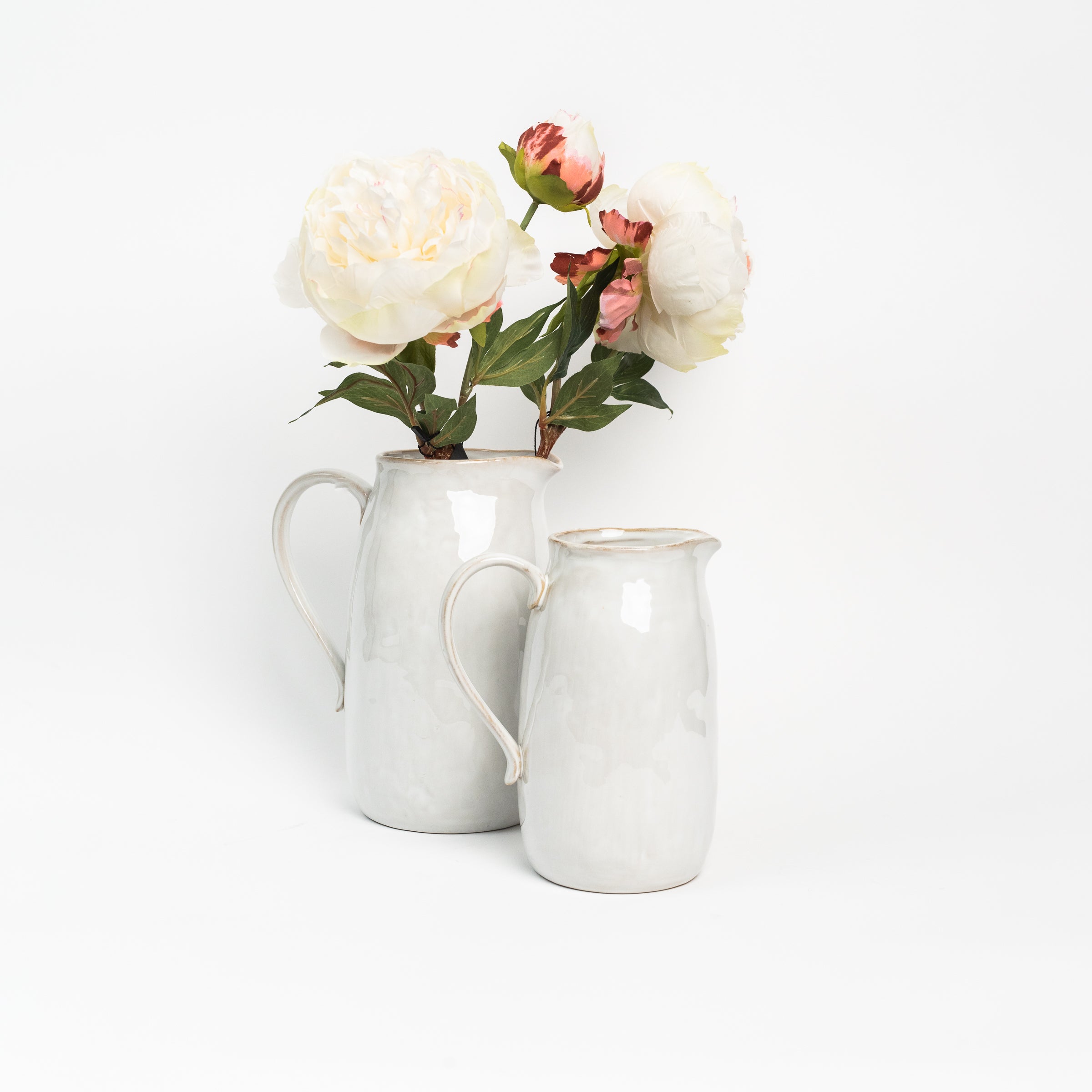 Stoneware Pitchers with flowers on a white background