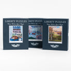 Three blue boxes of Liberty puzzles side by side on a white background