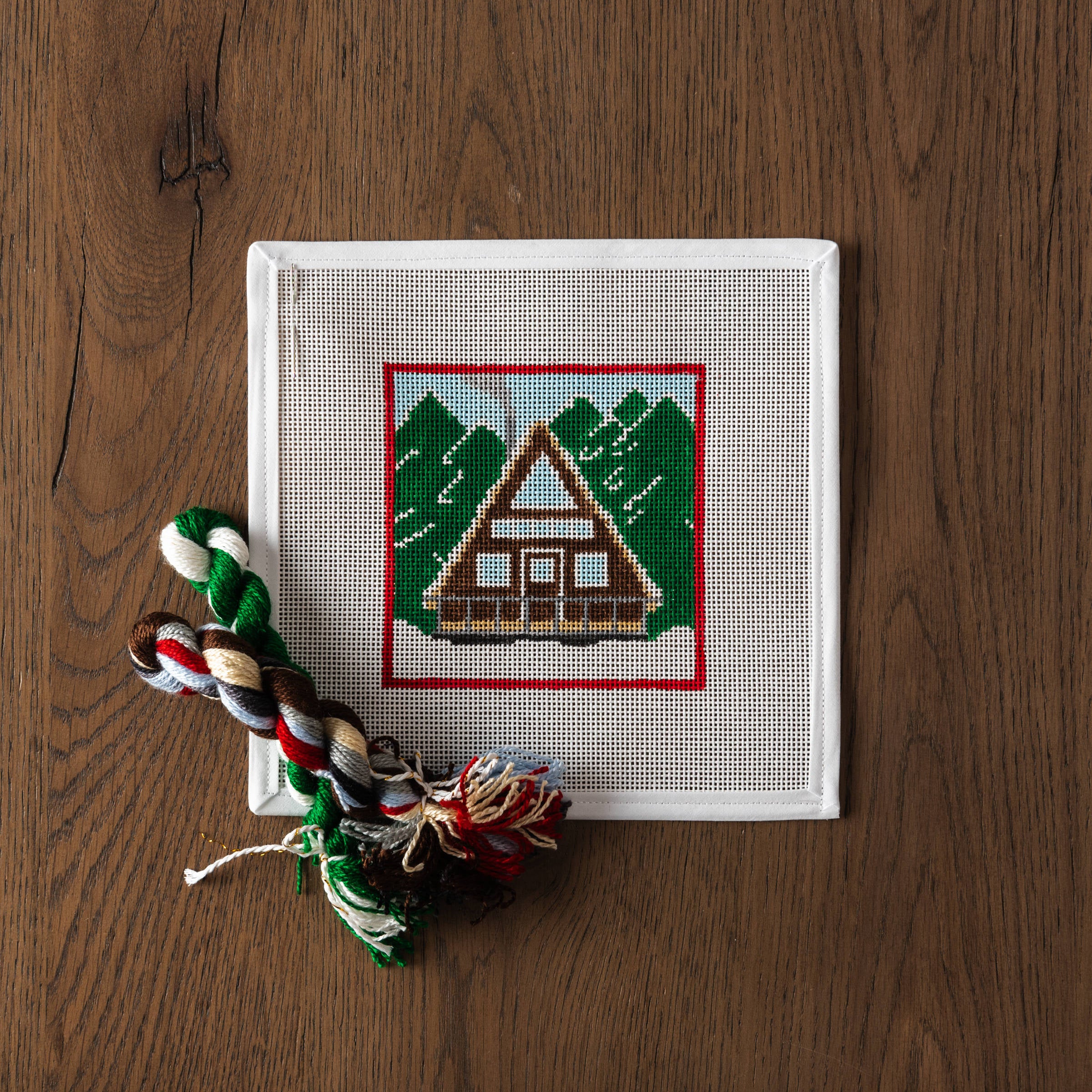 Chalet Needlepoint Kit on a wood table at Addison West