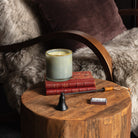 Lafco Sea and Dune Signature Candle on an end table in front of a furry arm chair at Addison West