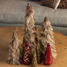 Set of three Feather Trees, Cast Aluminum Trees, and red glass trees on a coffee table in front of a grey sofa at Addison West