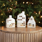 Ceramic Tealight Houses in front of a Christmas tree at Addison West