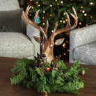 Dapper Deer on a coffee table in front of a Christmas tree at Addison West