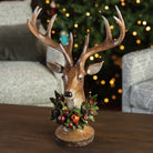 Dapper Deer on a coffee table in front of a Christmas tree at Addison West