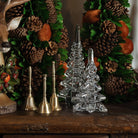 Set of 3 Clear Glass Trees, decorative brass bells, wood reindeer head statue on a table at Addison West