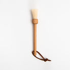 Round wood Pastry Brush with leather strap made in Germany on a white background at Addison West