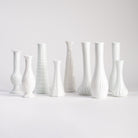 Collection of vintage milk glass vases on a white background at Addison West