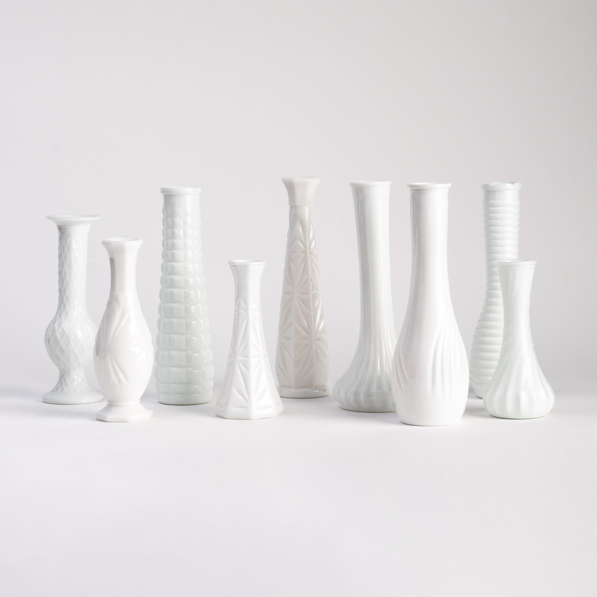 Collection of vintage milk glass vases on a white background at Addison West