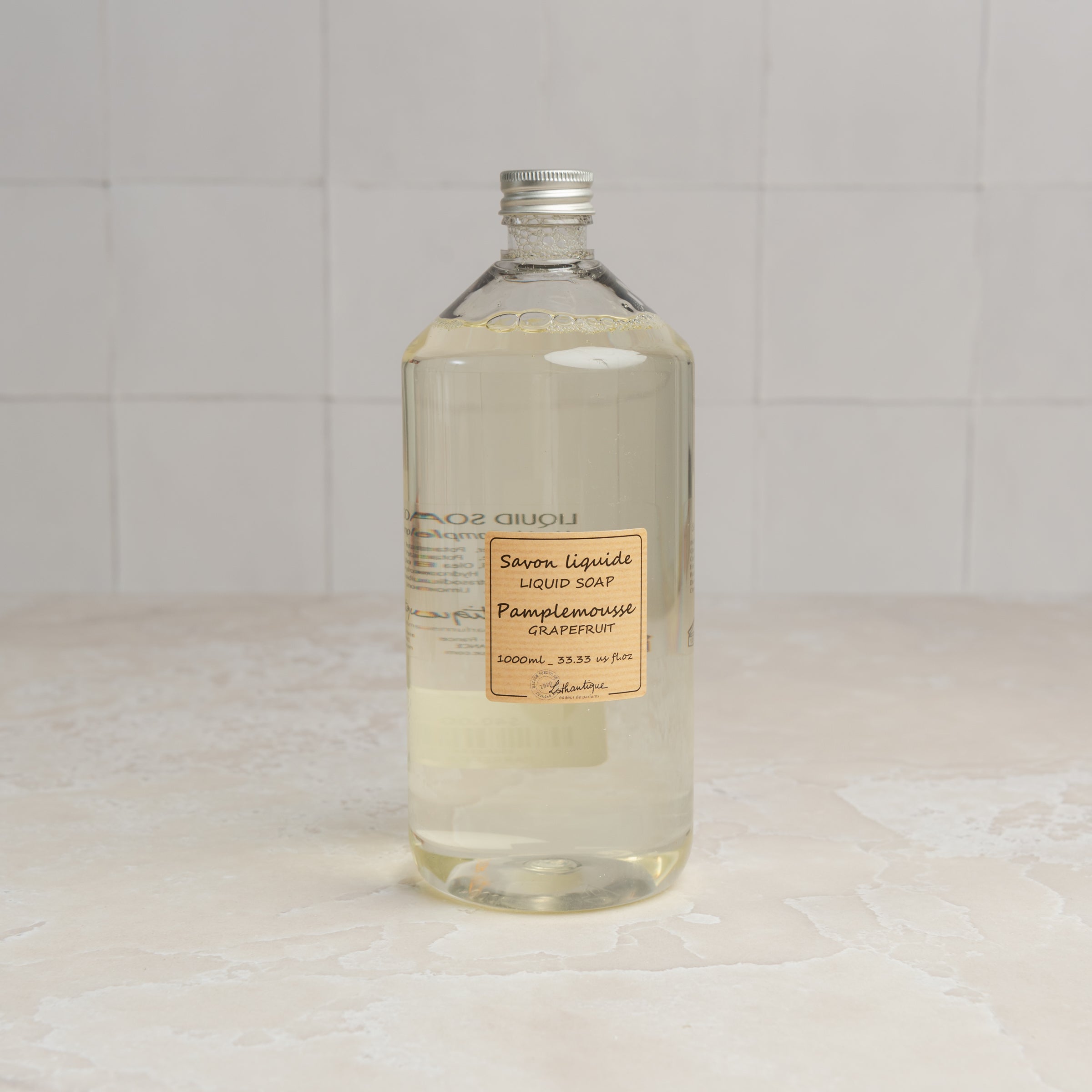 Lothantique Liquid Soap Refill - Grapefruit on a marble table at Addison West