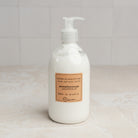 Lothantique Hand & Body Lotion - Grapefruit on a marble table at Addison West