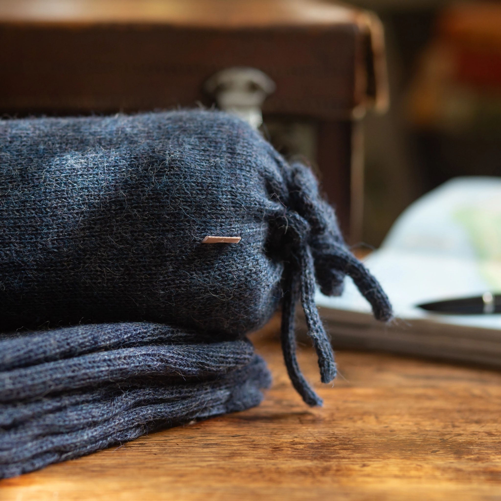 Blue grey Alpaca Travel Wrap on a wood desk