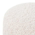 Close up of Four hands brand Aniston ottoman in natural shearling style upholstery on a white background