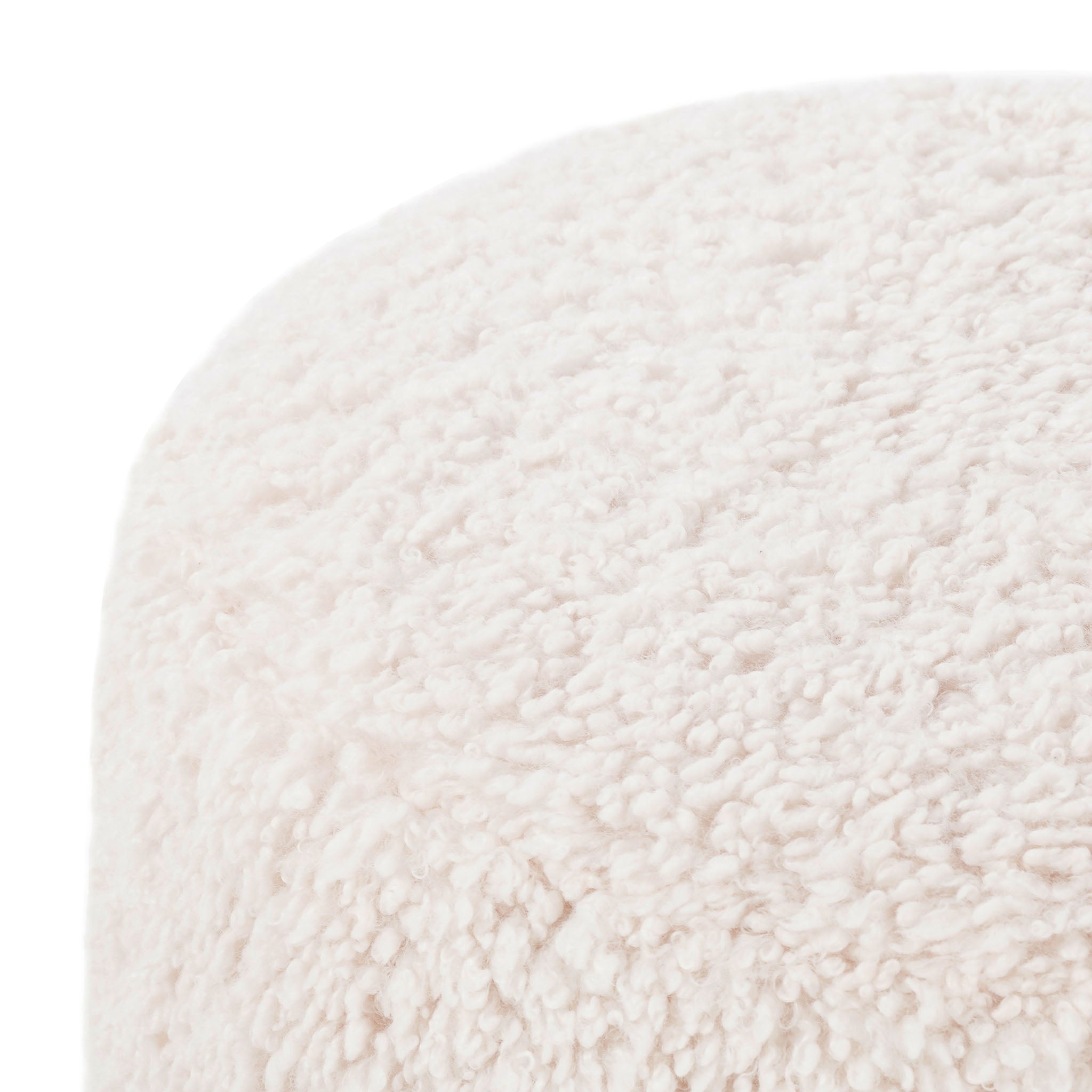 Close up of Four hands brand Aniston ottoman in natural shearling style upholstery on a white background