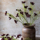 Abigail Ahern Faux Cosmos in Burgundy faux florals in a brown vase at Addison West