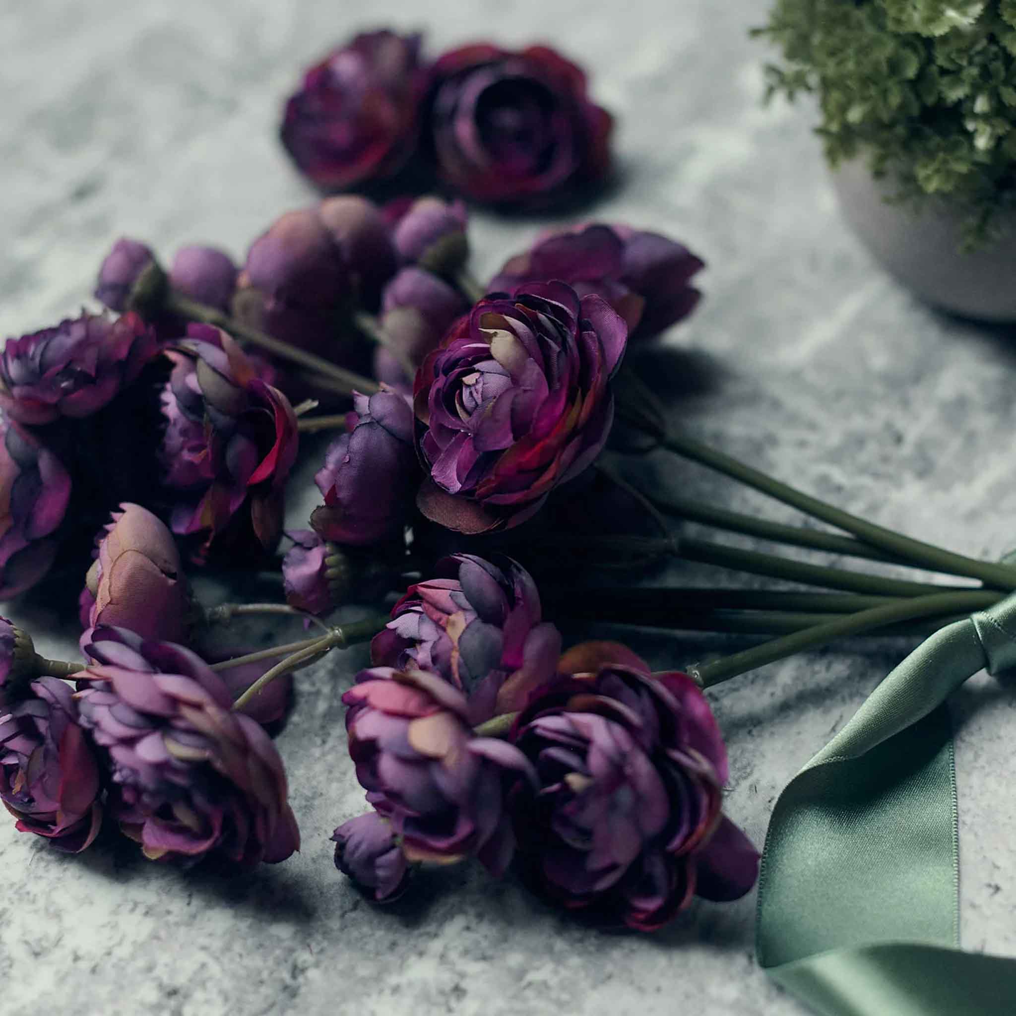 Close up of Abigail Ahern Faux Ranunculus Bunch in Purple on a grey table at Addison West