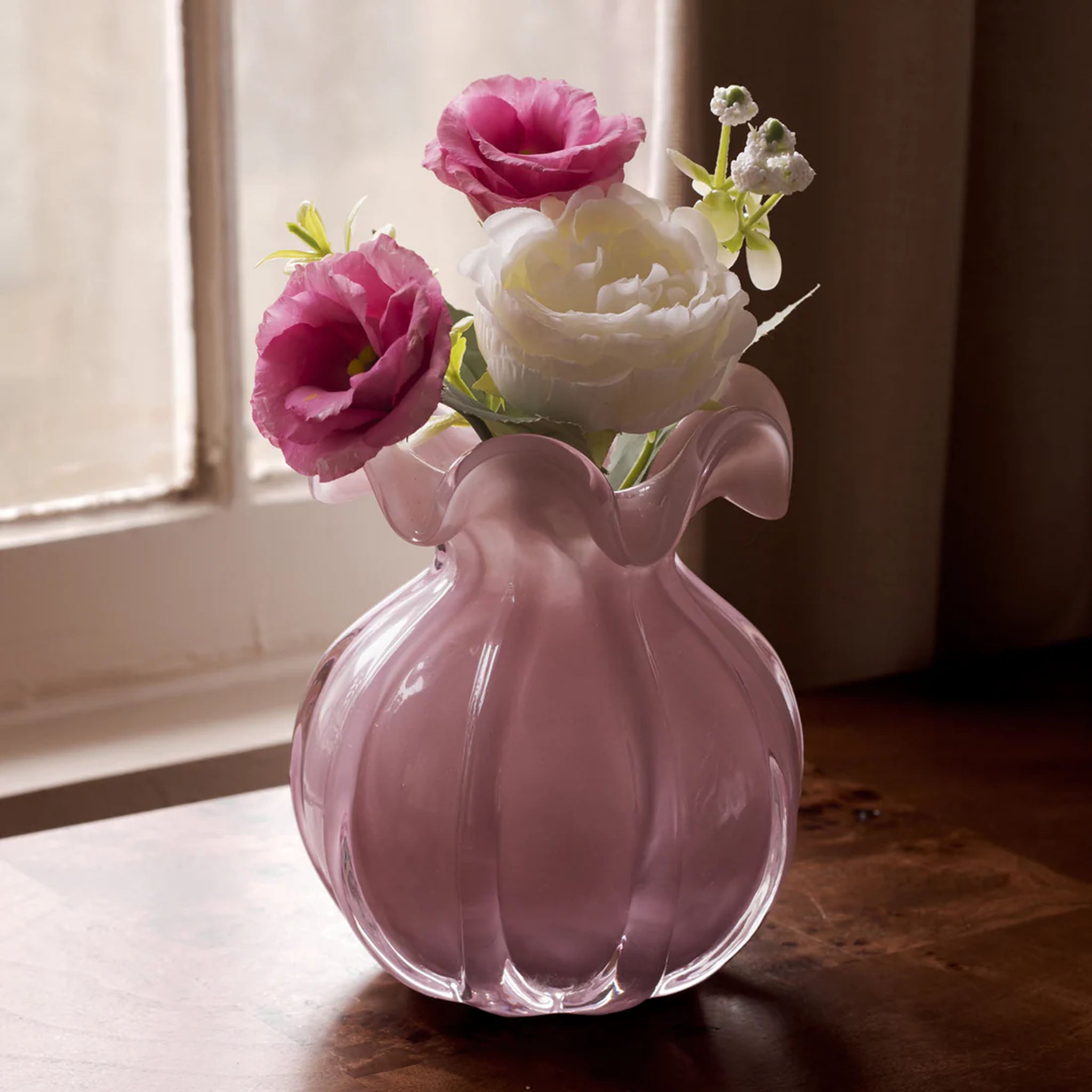 Beatriz Ball Medium Vento Bud Vase in Plum on a wood table in  front of a window at Addison West