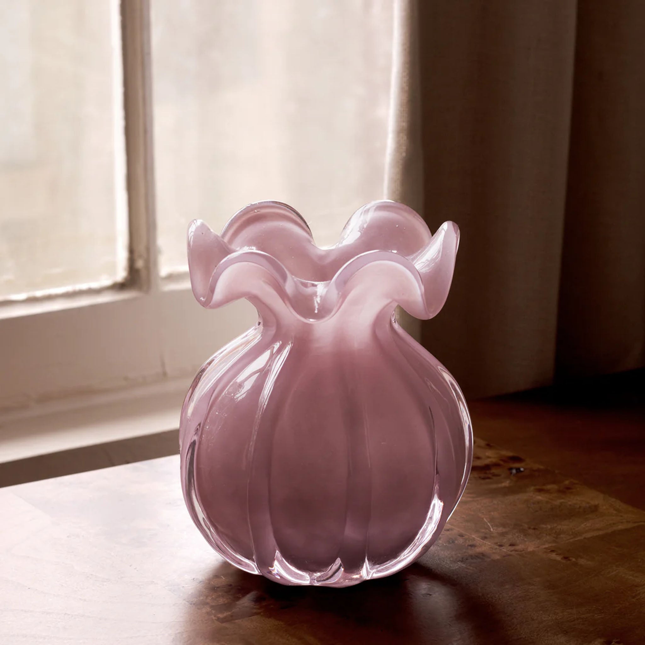 Beatriz Ball Medium Vento Bud Vase in Plum on a wood table in  front of a window at Addison West