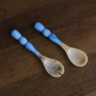 Beatriz Ball RESIN Rio Bubble Salad Servers in Blue on a wood table at Addison West