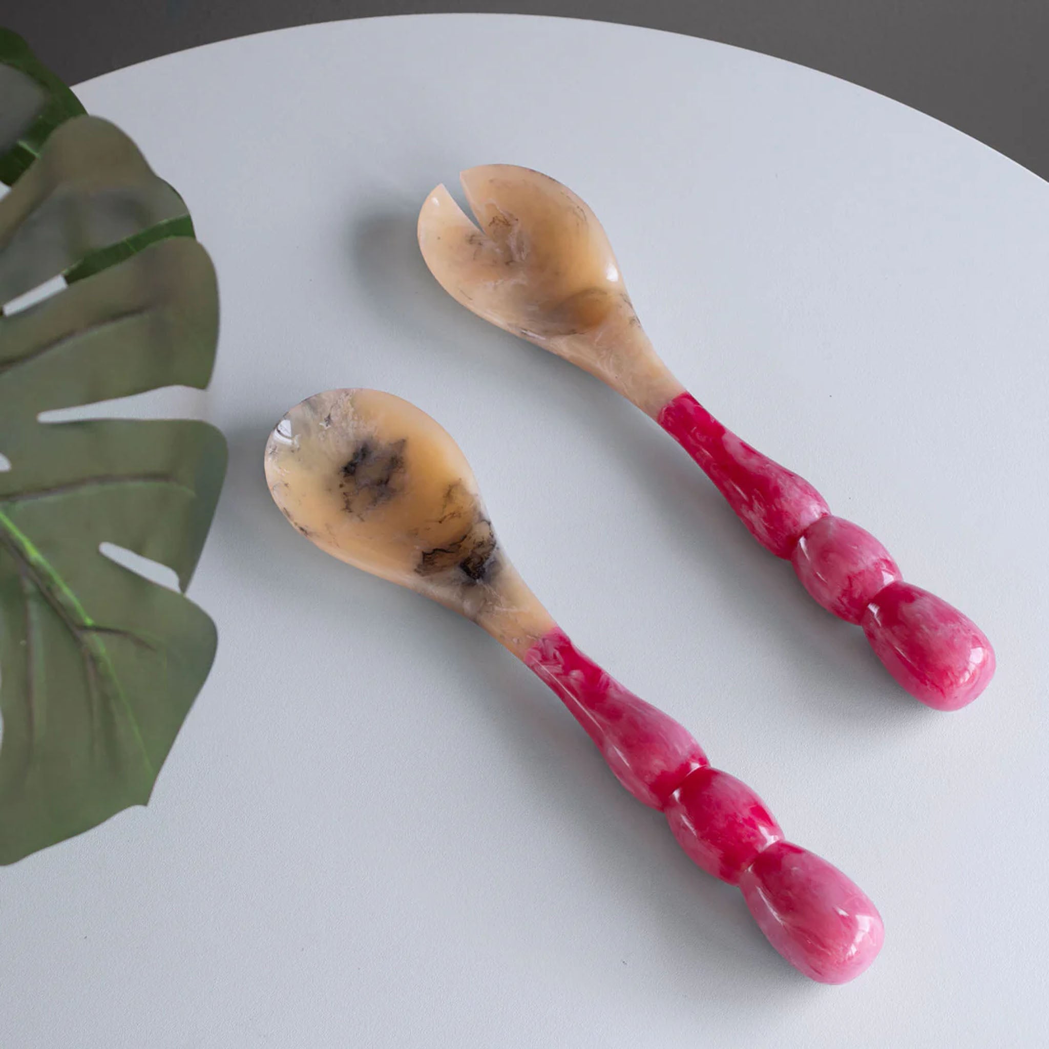 Beatriz Ball RESIN Rio Bubble Salad Servers in Pink on a white table at Addison West