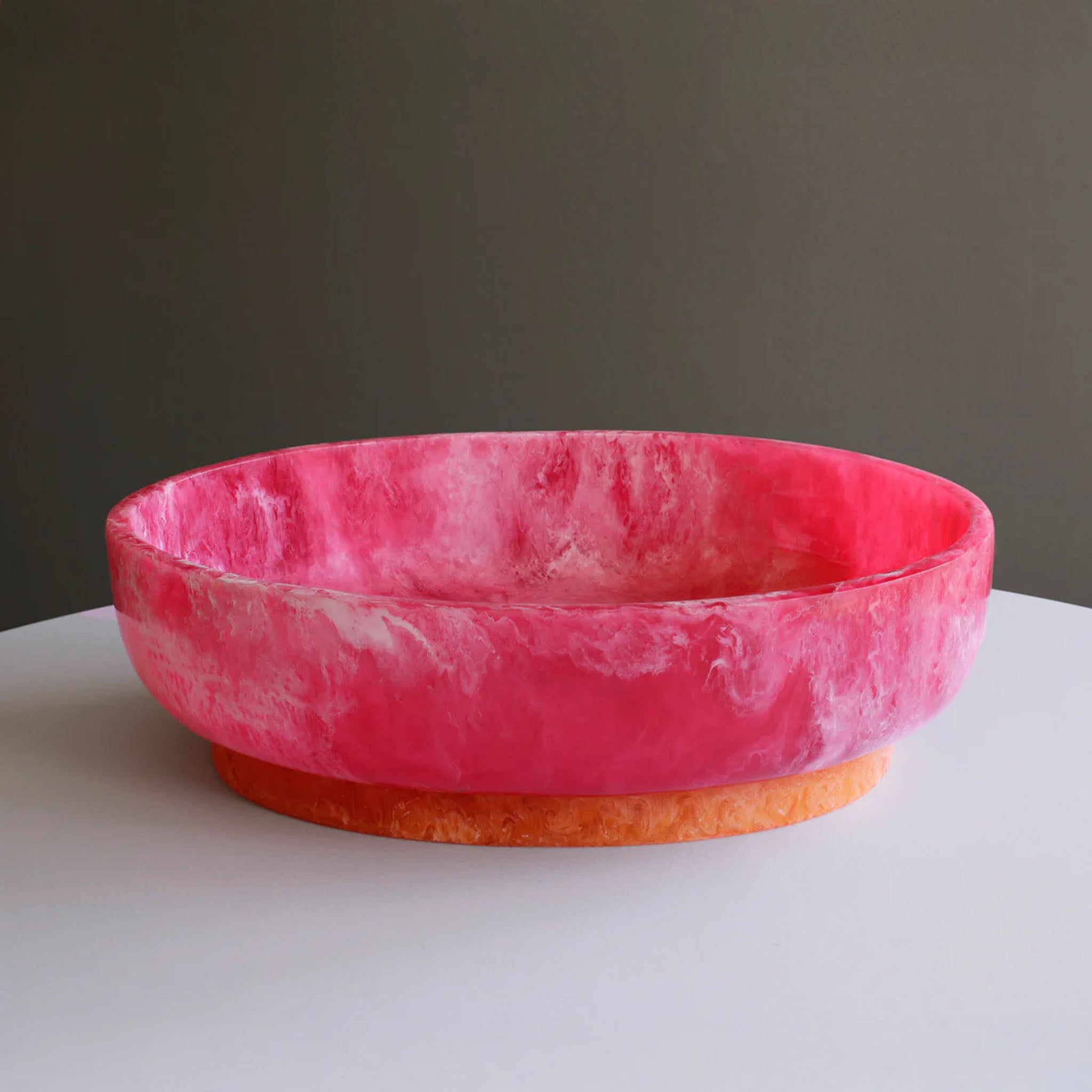 Beatriz Ball RESIN Rio Large Oval Bowl with Base in Pink & Orange on a white table at Addison West