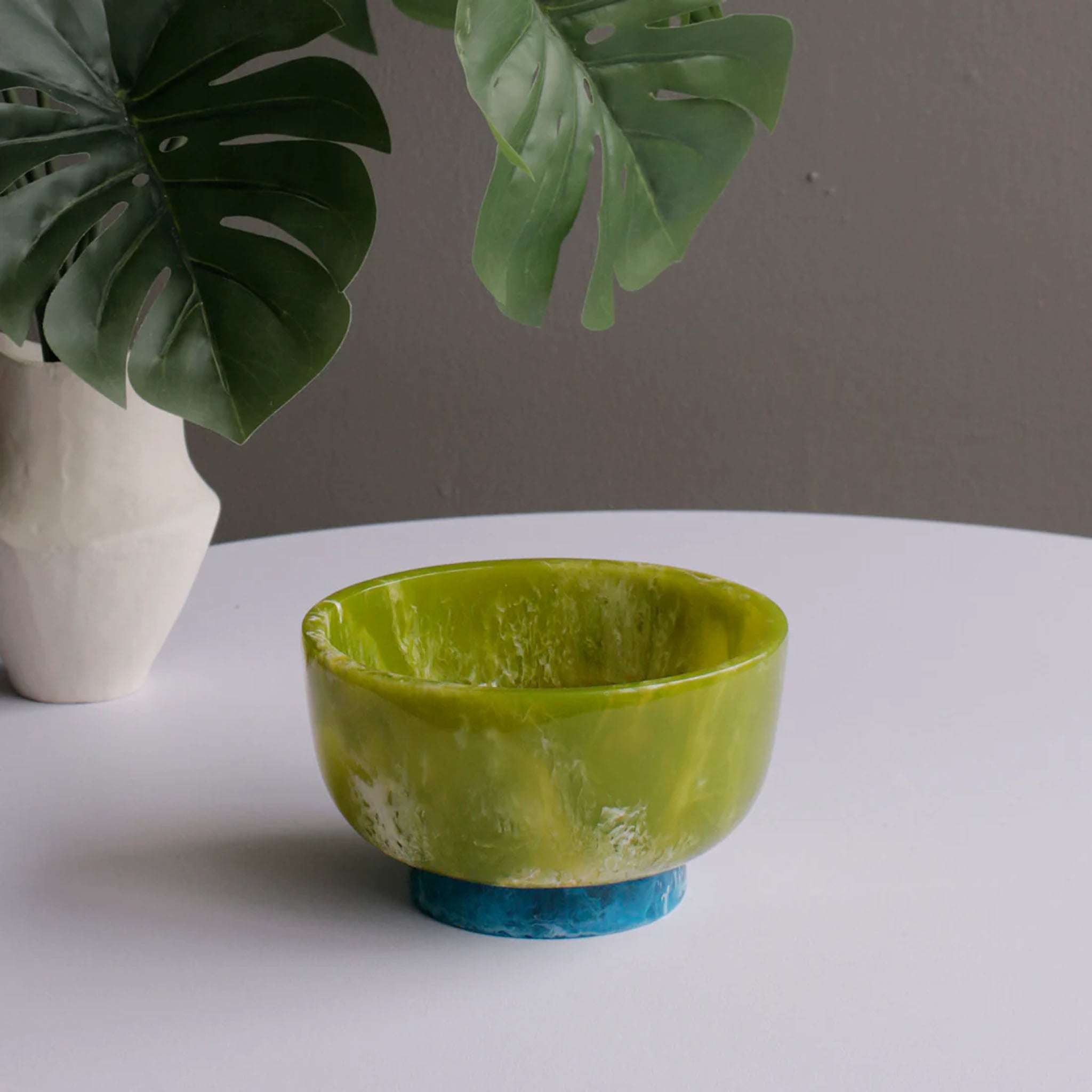 Beatriz Ball RESIN Rio Small Bowl with Base in Green & Blue on a white table at Addison West