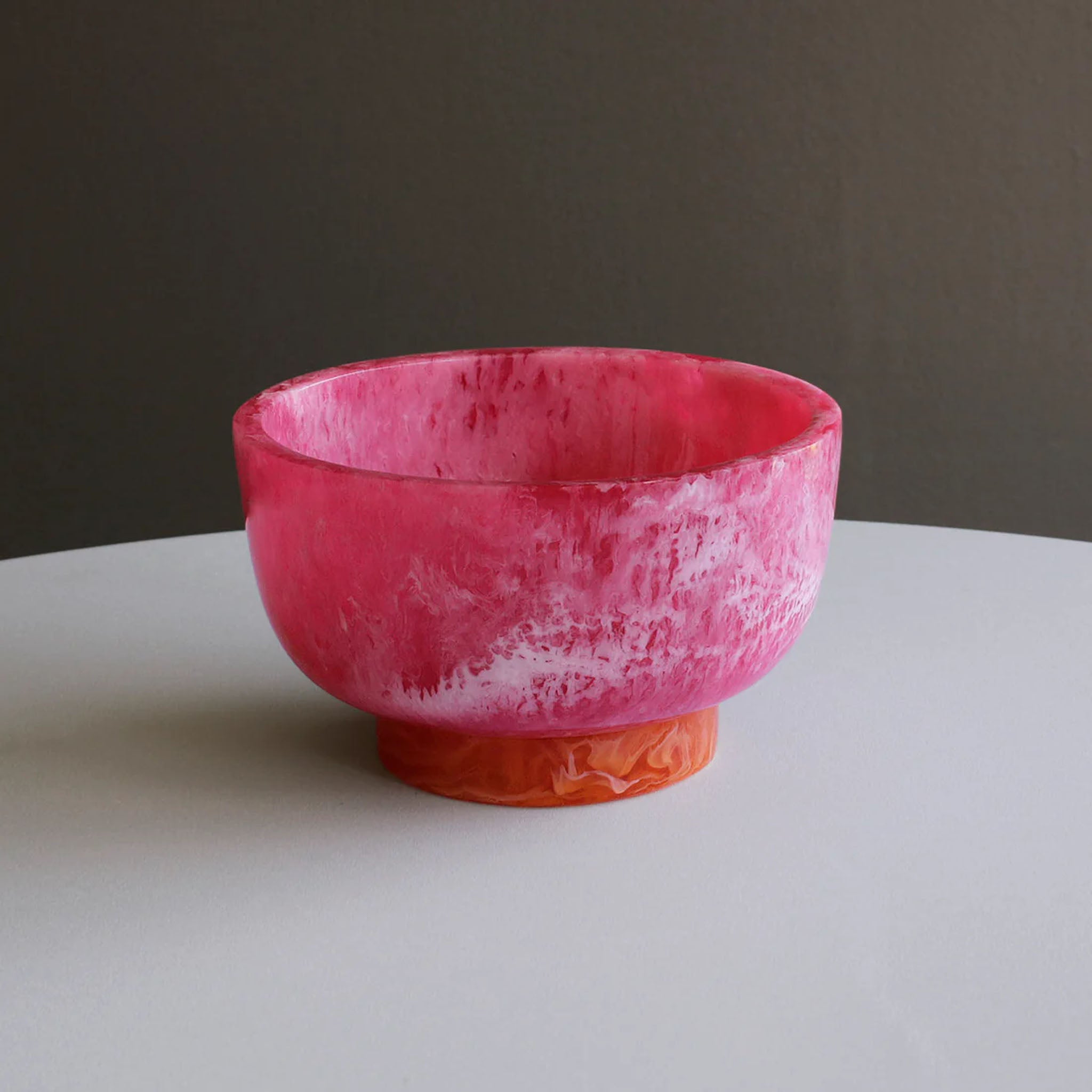 Beatriz Ball RESIN Rio Small Bowl with Base in Pink & Orange on a white table at Addison West