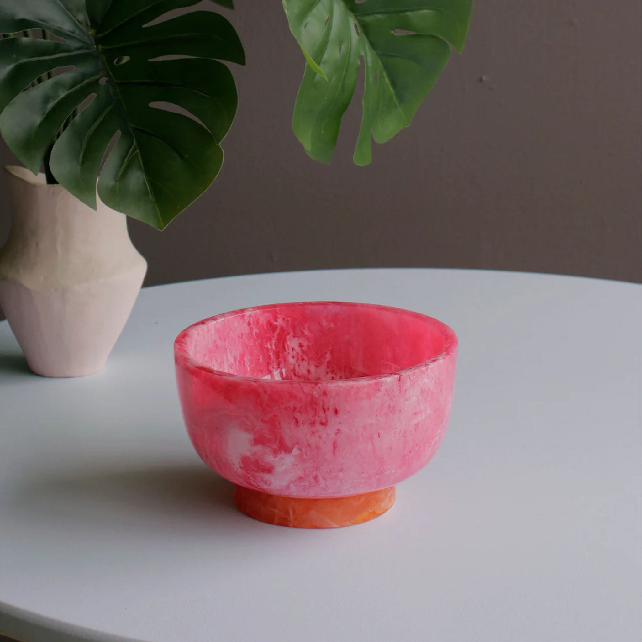 Beatriz Ball RESIN Rio Small Bowl with Base in Pink & Orange on a white table at Addison West